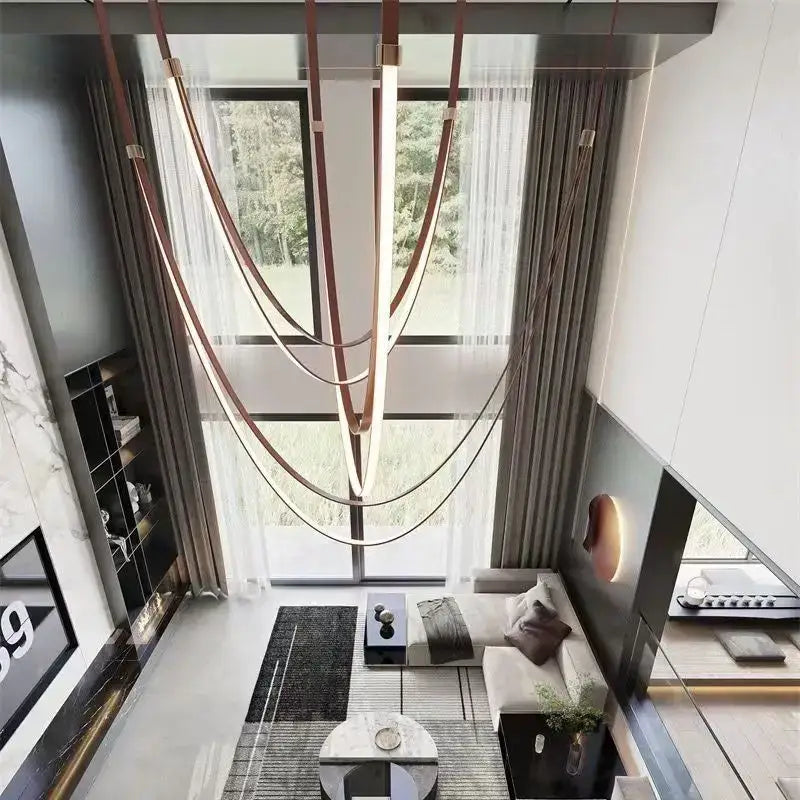 A modern white and brown leather chandelier with curved copper-toned belt pendant light for dining room