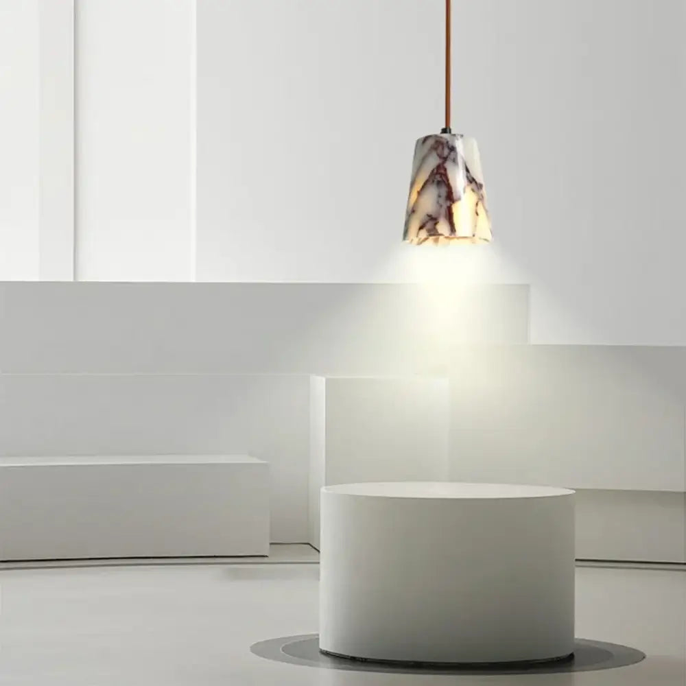 A sleek modern white and brown marble pendant lamp with bulgari stone led hangs in a dining room decorbites bulgari stone