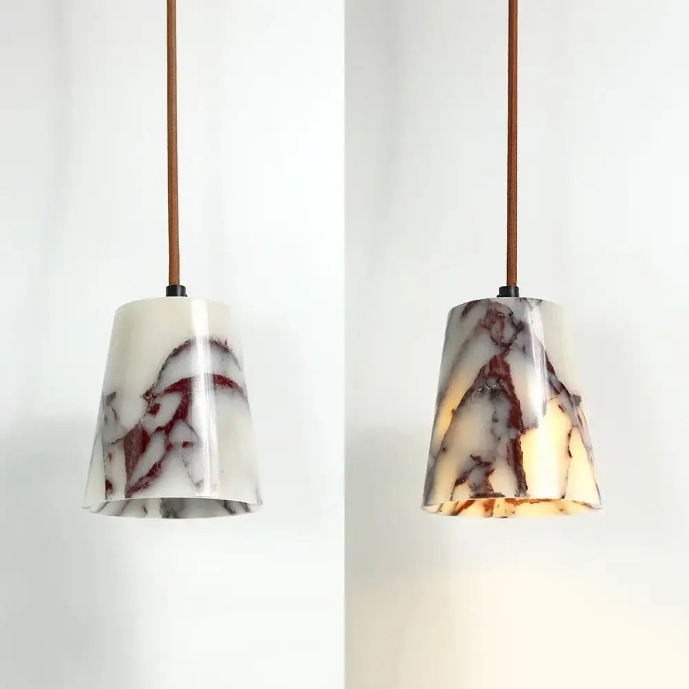 A sleek modern pendant lamp with white and brown bulgari stone led finish suspended by a brown leather cord