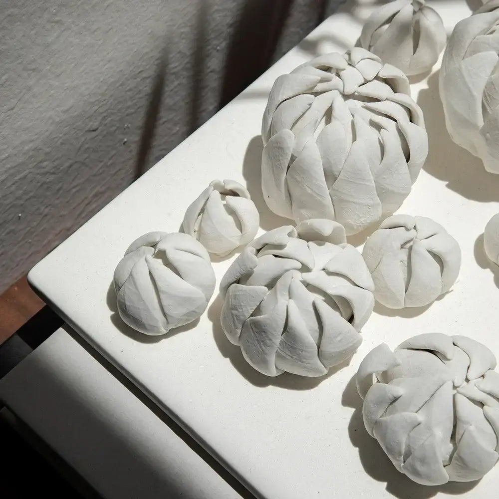 Modern white bud ceramic wall décor pendant with intricate folded petal designs for bedroom sculptural art