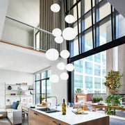 Modern white cascading glass pendant light features spherical glass pendant lights hanging in a cluster for dining room