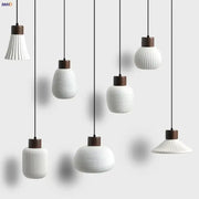 Modern white ceramic pendant light fixture with vertical ridges and dark wood accents for kitchen decor