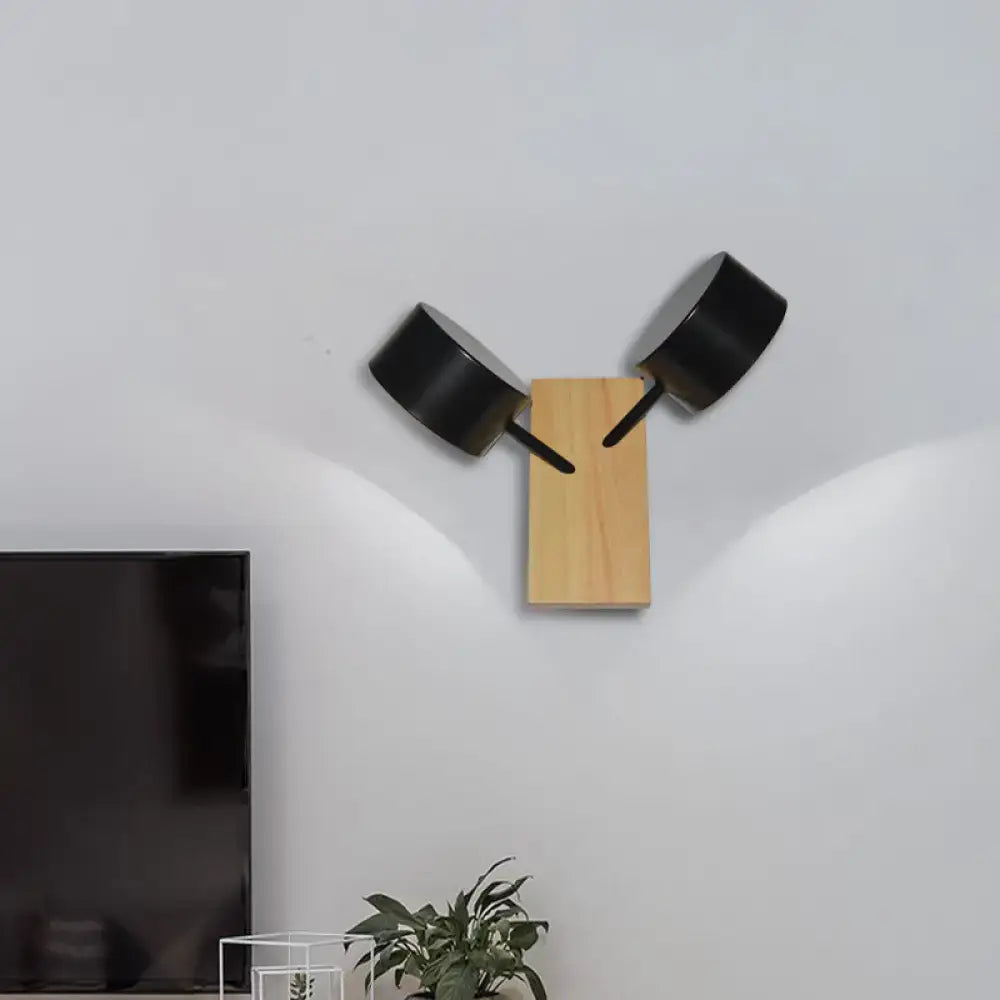 Modern white ceramic double drum wall sconce with black cylindrical lamp heads on wood base suitable for 220v-240v use