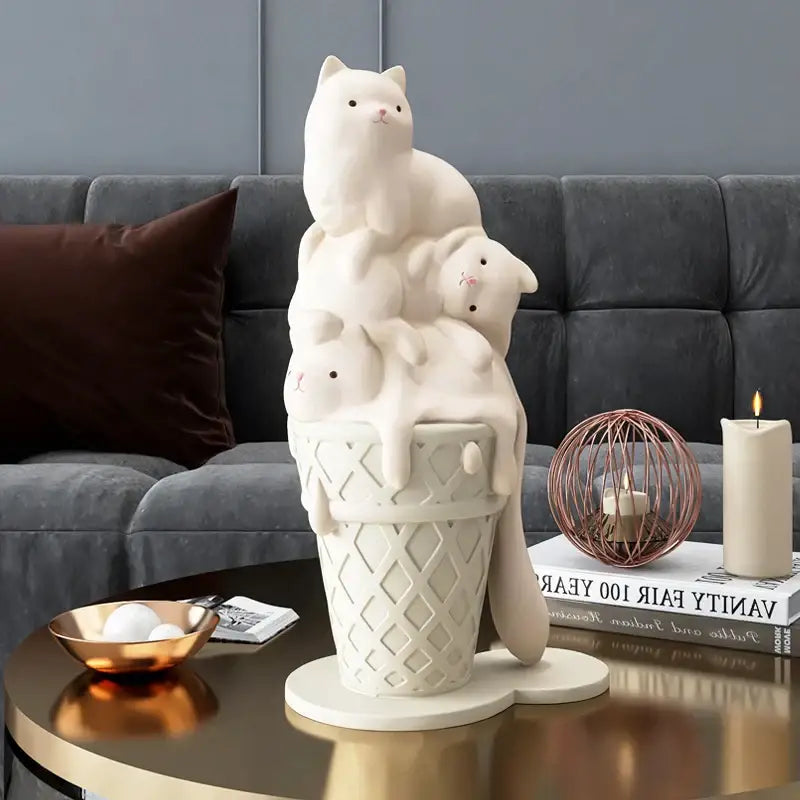 Cream-colored ceramic ice cream cat sculpture with three cats stacked on a waffle cone for modern living room decor