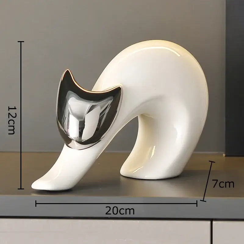 A sleek white ceramic kitten statue with a glossy finish and reflective silver face for modern living room decor