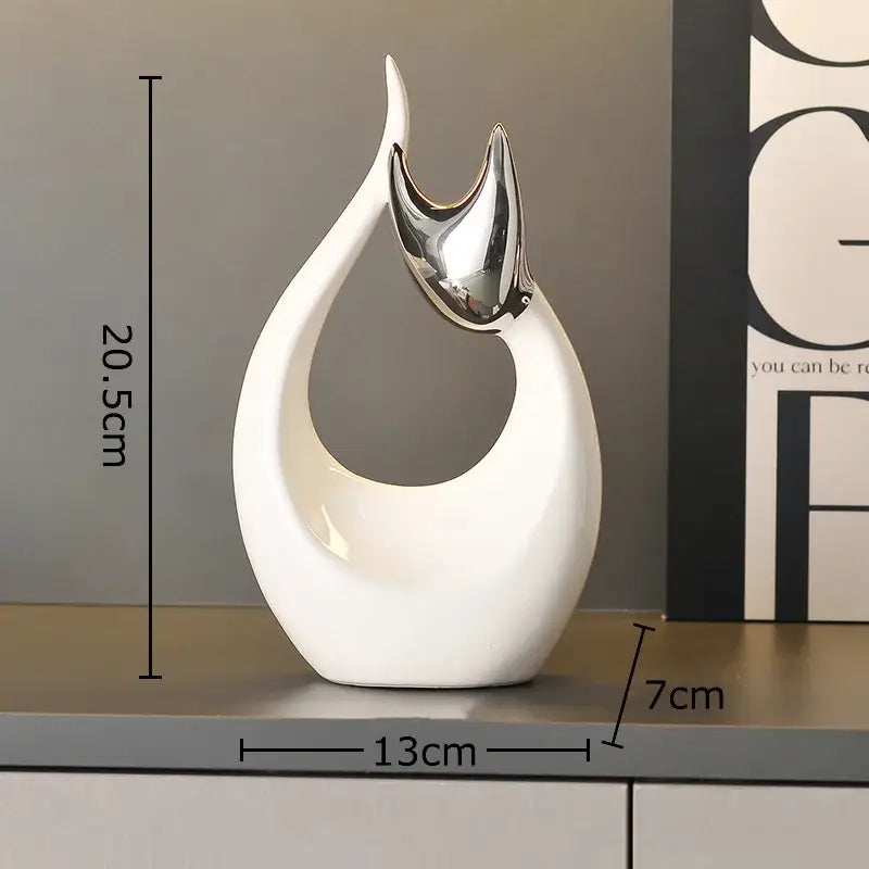 A sleek white ceramic kitten statue with glossy finish and silver metallic accent for modern living room decor