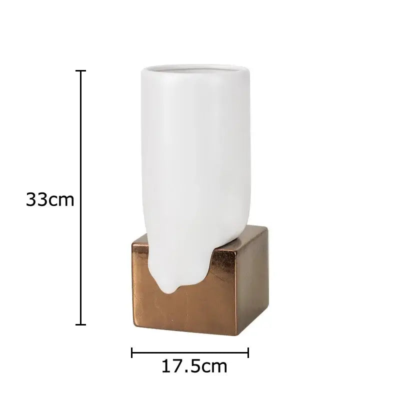 A sleek white decorbites ceramic liquid vase with a glossy finish mounted on a bronze base for modern decor