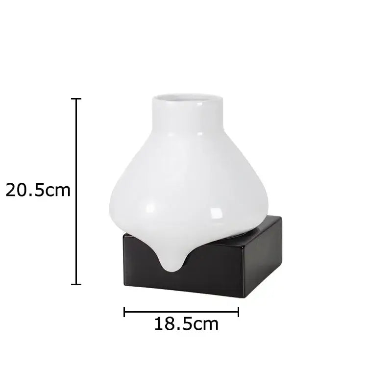 A sleek white decorbites ceramic liquid vase with a glossy finish and black square base for modern living room decor