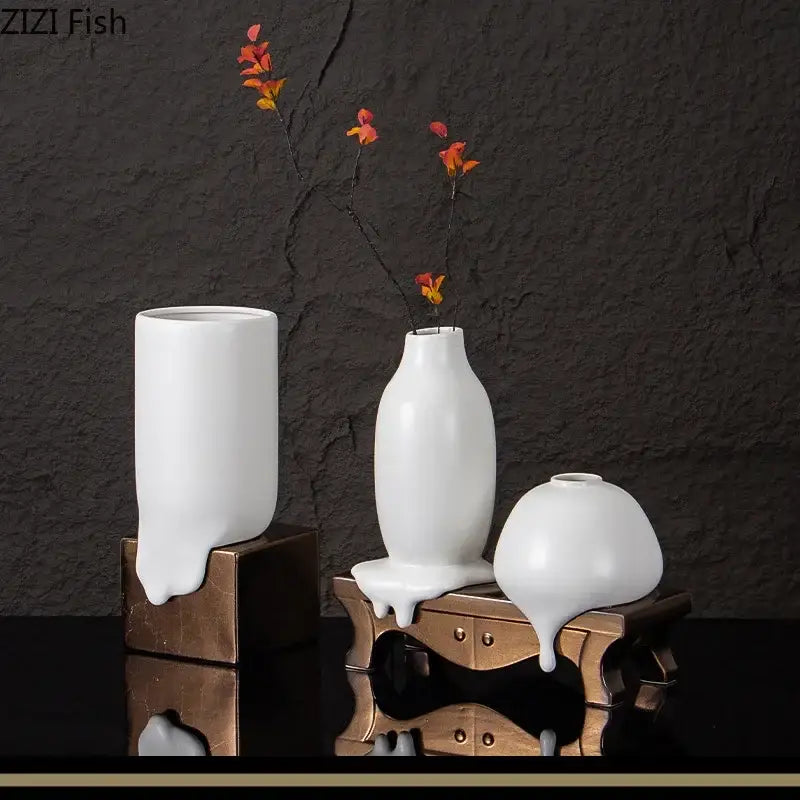 Set of three modern white decorbites ceramic liquid vases with glossy finish on ornate bronze stands for living room decor