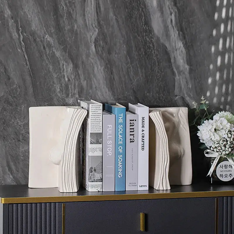Cream-colored ceramic open-book bookends complement modern white ceramic man face decorbites ceramic man face vase decor