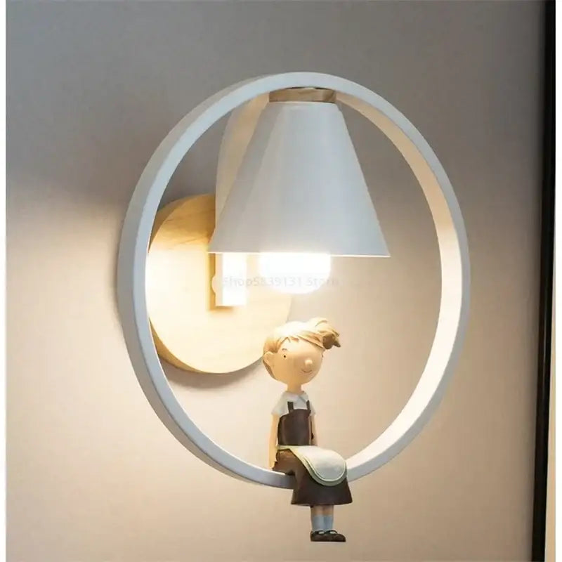 Modern white led wall lamp with a child figurine in overalls sitting on the circular frame for bedroom use