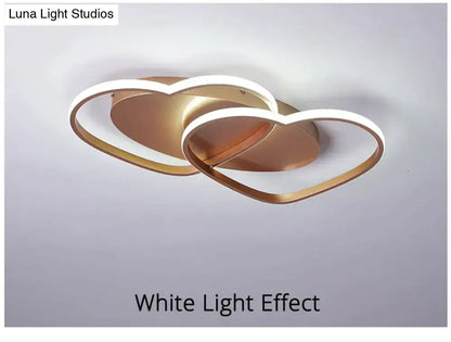 Modern white coffee pendant light featuring a gold-toned led fixture with interlocking heart-shaped rings and illuminated edges