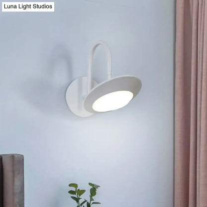Modern white and coffee wall sconce lamp with sleek curved arm and circular led light for bedroom use