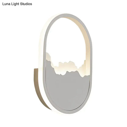 Modern white cracked design oval sconce lamp with gray frame and illuminated mountain silhouette for stairway lighting
