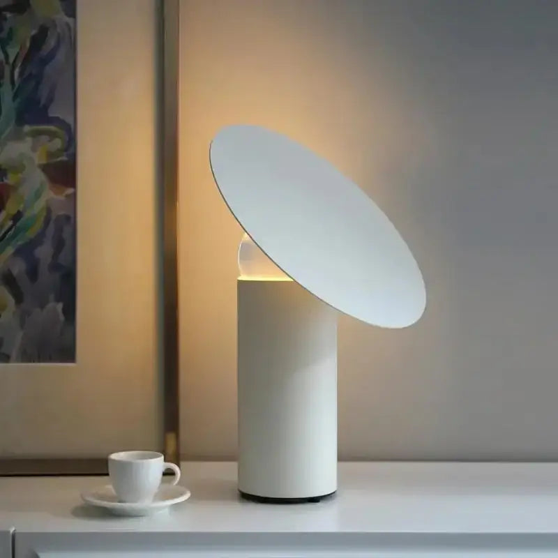 Minimalist white crystal ball table lamp with cylindrical base and tilted disc shade emitting warm ambient light for decorbites crystal ball decor