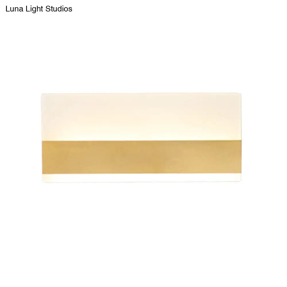 Modern white cuboid design wall sconce with a sleek white warm light diffuser and polished gold accent band for bedroom use