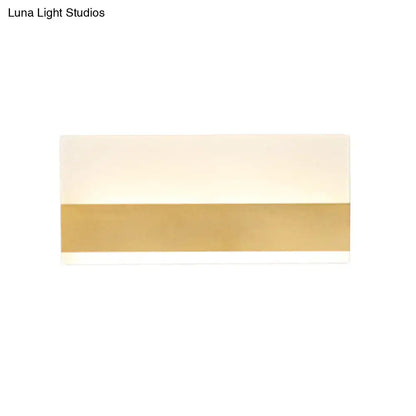 Modern white cuboid design wall sconce with a sleek white warm light diffuser and polished gold accent band for bedroom use