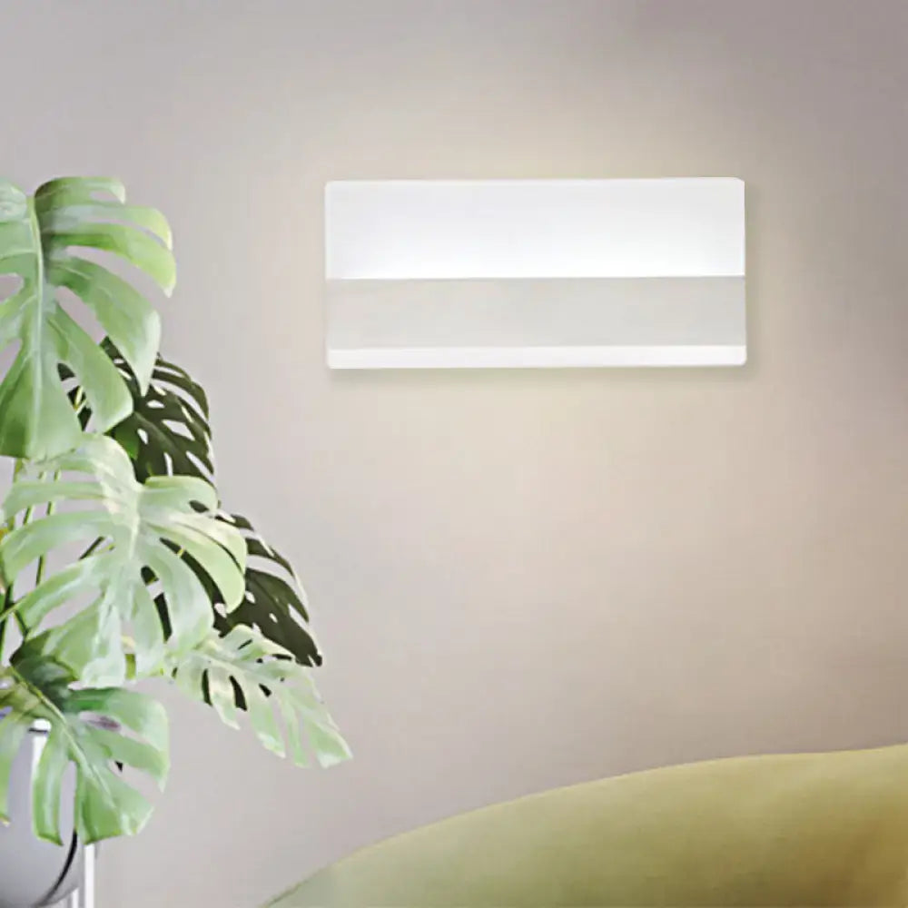 Modern white cuboid design wall sconce with sleek minimalist style emitting warm white light for bedroom use