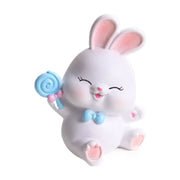 Modern white cute bunny figurine sculpture with pink ears and blue bow tie holding a blue lollipop for bedroom decor