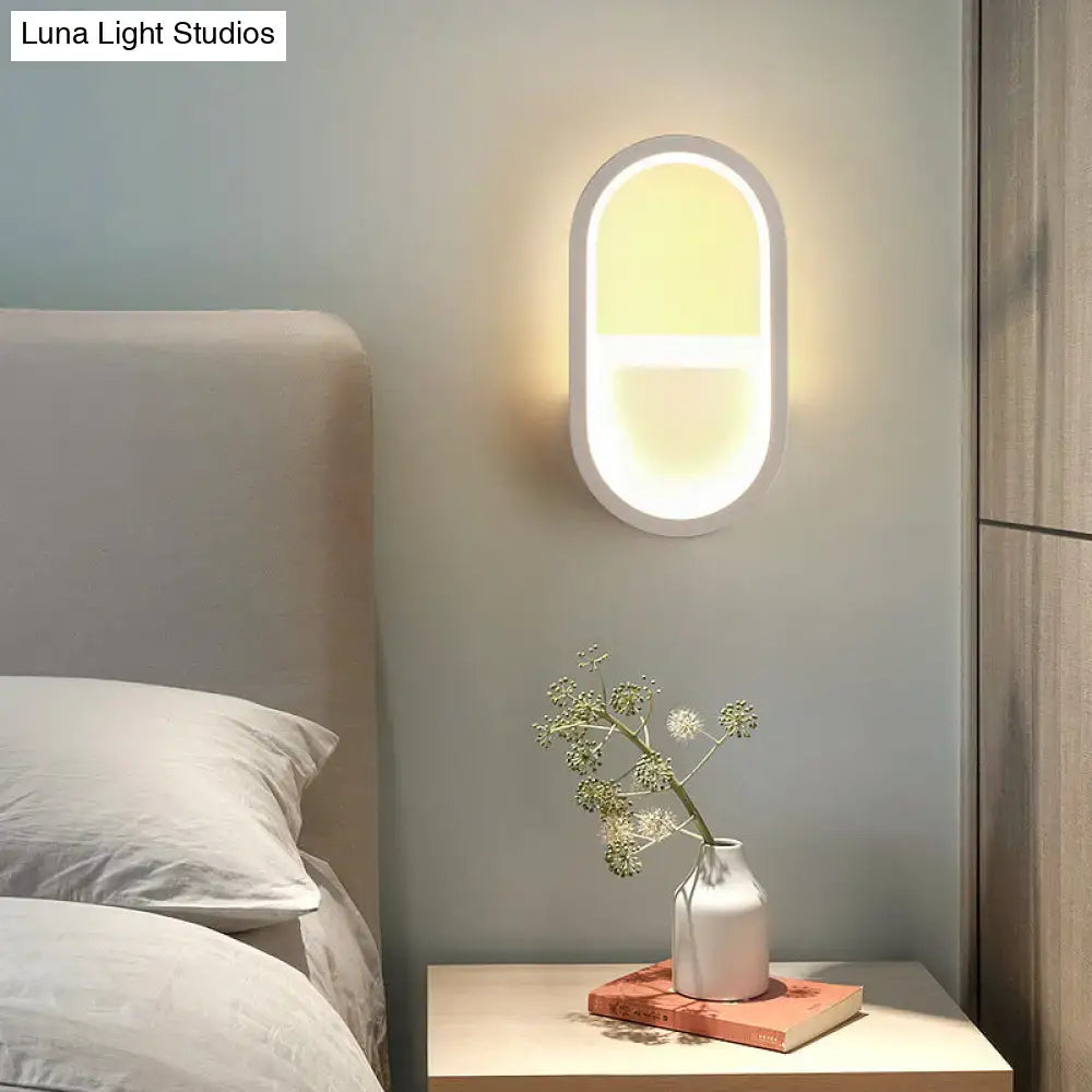 Modern white elliptical led wall lamp with a sleek frame and soft warm light for bedroom use as a wall sconce