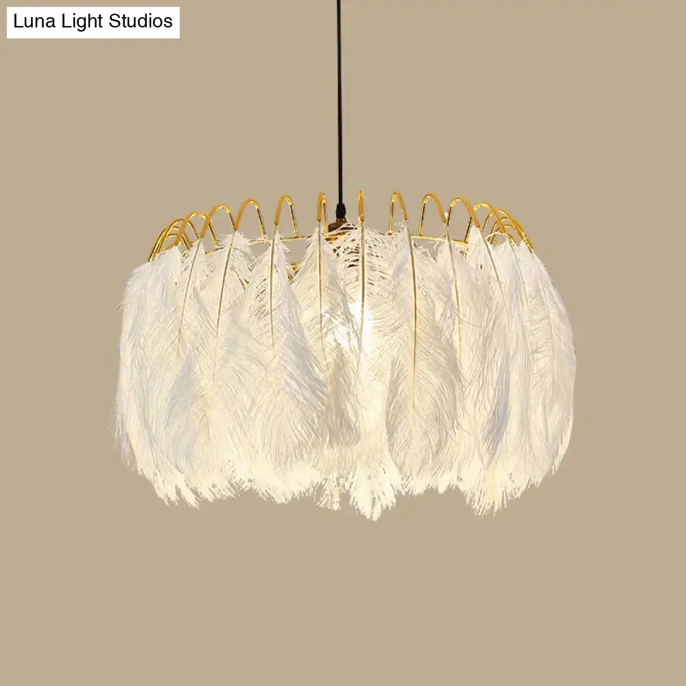 Modern white feather chandelier with a gold-toned metal frame designed as a living room pendant light