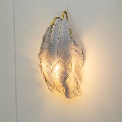 Modern white feather metal wall sconce with gold-toned frame for elegant bedroom lighting and modern metal decor