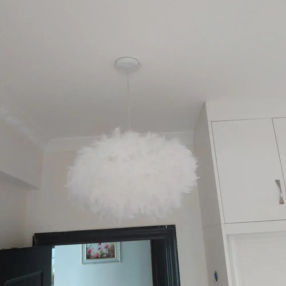 Modern white feather pendant light with fluffy white feather design and chrome finish hanging from ceiling fixture