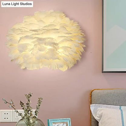 A modern cream-colored feather wall lamp with a fluffy layered design for stylish home decoration bedroom use