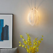 Modern white feather wall sconce with soft white feathers and warm glow for bedroom single bulb lighting