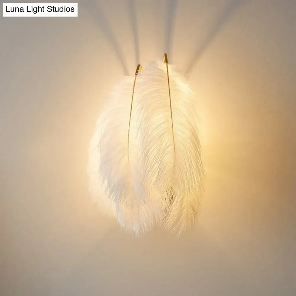 Modern white feather wall sconce with soft fluffy texture and gold-toned metal fixtures for bedroom single bulb light