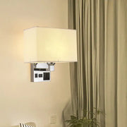 Modern rectangular wall sconce with a cream-colored fabric shade and chrome-finished metal base featuring integrated usb ports.