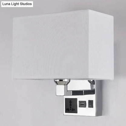White rectangular fabric shade mounted on a chrome-finished wall sconce with integrated power outlets and usb port.