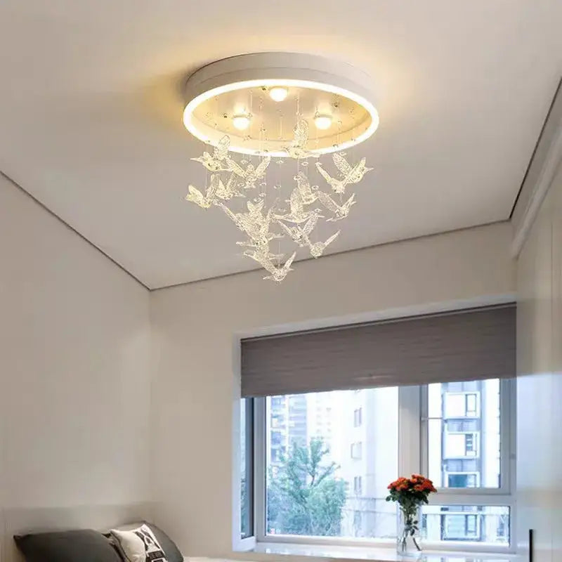 Modern white flying bird ceiling light for kids bedroom with circular base, embedded bulbs, and transparent crystal decorbites flying bird ornaments