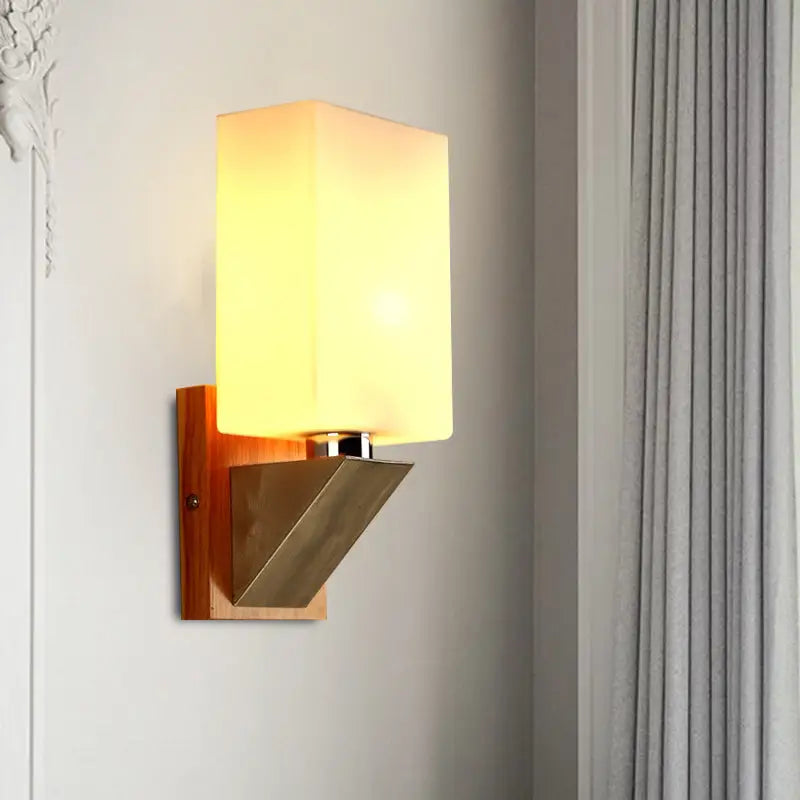 Modern warm-toned wall lamp with white frosted glass shade and wooden base with metal accents for bedroom use