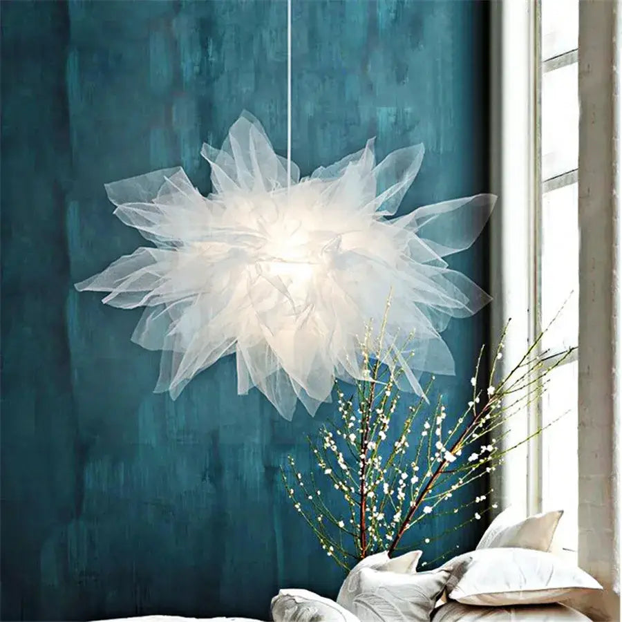 Modern white gauze flower pendant light featuring a delicate white tulle chandelier against a deep teal wall by decorbites gauze