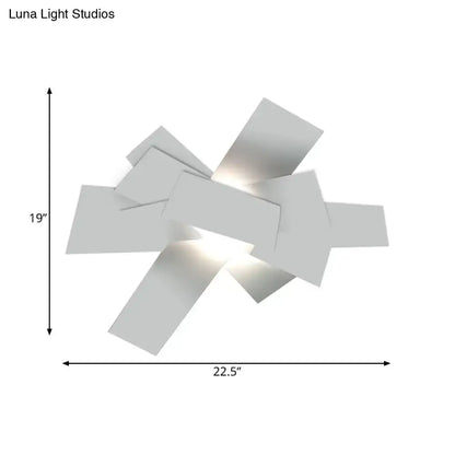Modern white geometric wall sconce with angular overlapping panels featuring 110v-120v bulb base for bedroom use