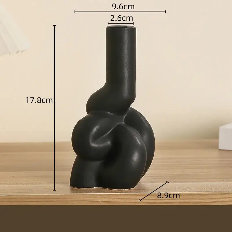 Black ceramic vase with abstract knotted design paired with decorbites geometric ceramic candle holders for living room decor