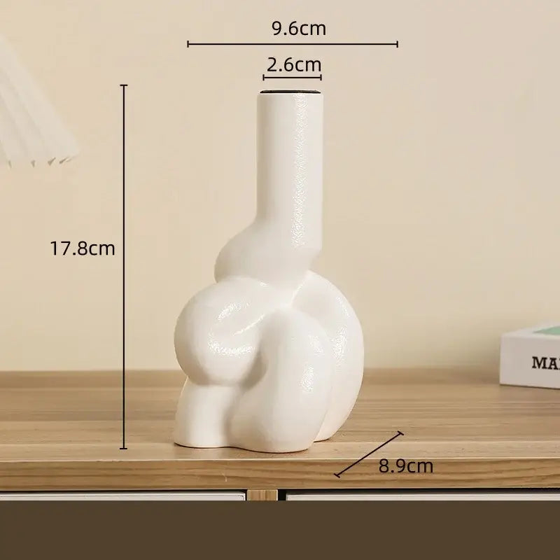 A sleek white geometric ceramic candle holder with a sculptural design for modern living room decor by decorbites
