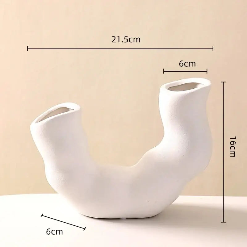 A sleek white modern geometric ceramic flower vase with u-shaped design and asymmetrical openings for decorbites decor