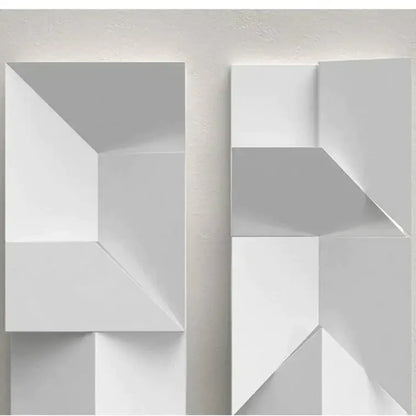 Modern white geometric wall lamp with angular three-dimensional facets illuminated for living room art