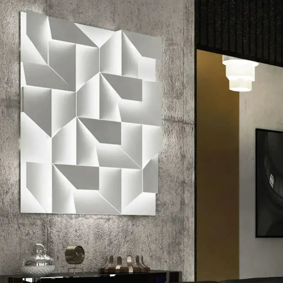 Modern white geometric wall lamp with three-dimensional design illuminating a living room space