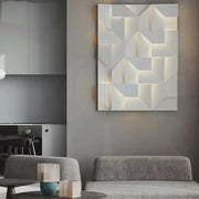 Modern white geometric wall lamp with illuminated recessed panels creating a three-dimensional angular pattern