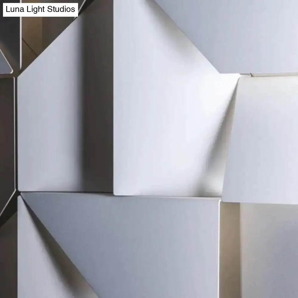 Modern white geometric wall lamp with smooth matte white and metallic surfaces in an angular living room design