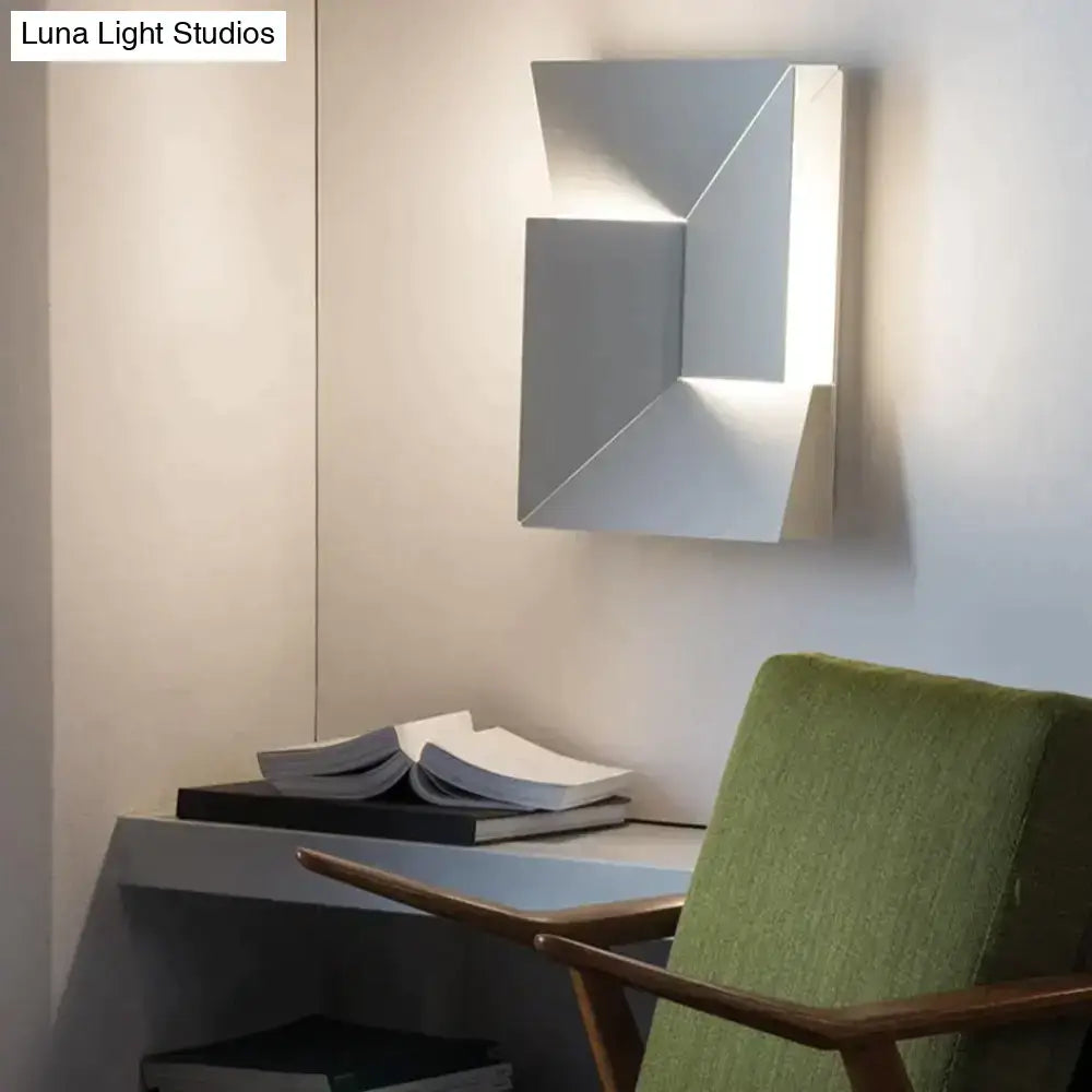 Modern white geometric wall lamp with sleek silver metallic finish and angular faceted design for living room art illumination