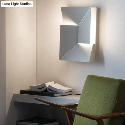 Modern white geometric wall lamp with sleek silver metallic finish and angular faceted design for living room art illumination