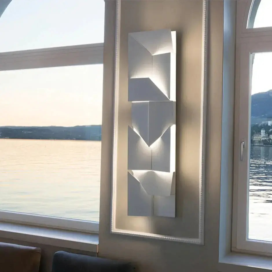 Modern white geometric wall lamp with layered angular panels and integrated lighting for living room decor