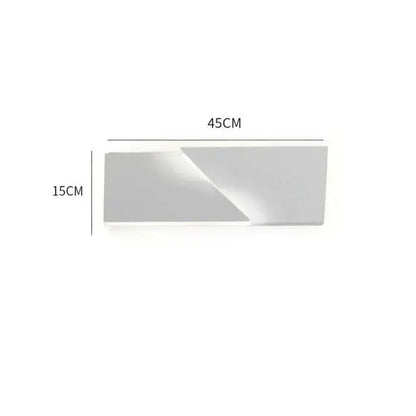 A sleek minimalist rectangular silver mirror with clean geometric edges complements a modern white geometric wall lamp