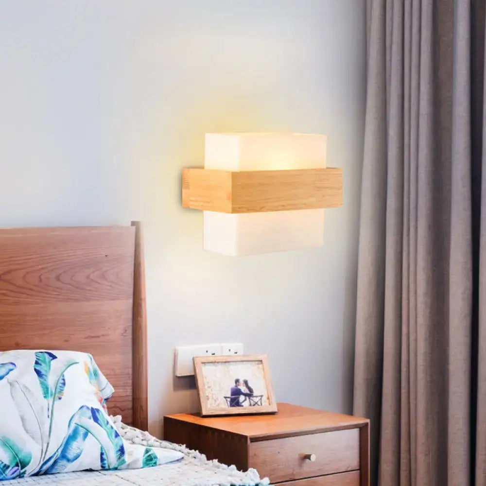 Modern wall light featuring a warm frosted white glass panel with natural wood accents for bedroom use
