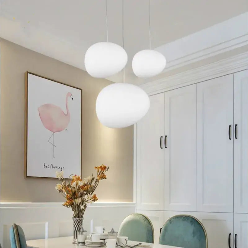 Three white glass ball led pendant lights hang from the ceiling in a modern dining room decorbites glass ball set