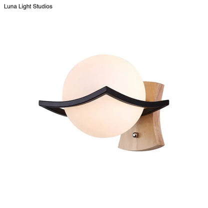 Modern white glass ball sconce with black accent and light wood base direct wired electric great addition for bedroom